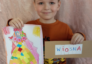 Chłopiec pokazuje swą pracę.