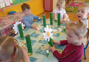 dzieci malują rolkę po ręczniku na zielono