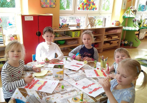 Dzieci wyklejają kontur hiszpańskiej flagi