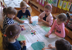 Dzieci pracują przy stolikach