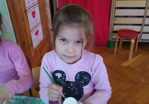 Dziewczynka maluje papierowy kubek na szaro
