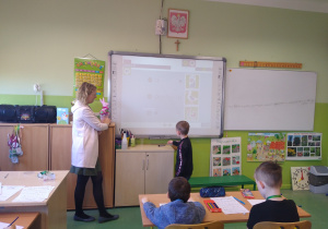 Chłopiec wykonuje zadanie na tablicy interaktywnej