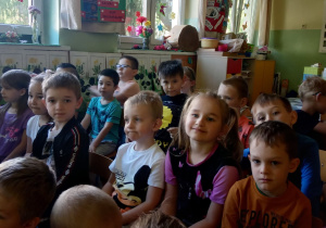 Dzieci przysłuchują się wykonawcom audycji muzycznej.