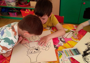 Dzieci kolorują kolorowanki z postaciami z czeskich bajek