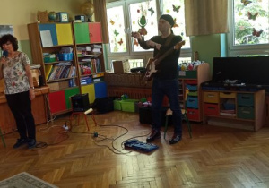 Pan pokazuje instrument muzyczny- gitarę elektryczną