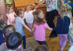 dzieci tańczą w kółeczku z panią