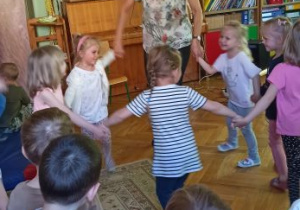 dzieci tańczą w kółeczku z panią