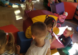 Dzieci budują tor przeszkód dla maskotek i autek.