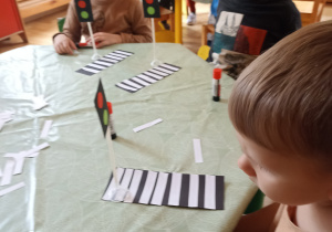 Dzieci wyklejają zebrę z papieru kolorowego
