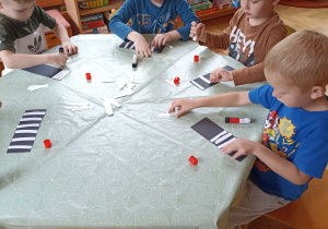 Dzieci wyklejają zebrę z papieru kolorowego