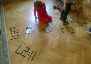 dzieci tworzą cyfry z pałeczek