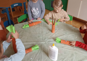 dzieci malują rolkę po ręcznikach papierowych