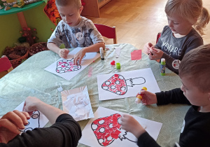 dzieci wyklejają papierem kolorowym muchomora