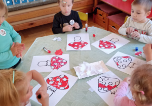 dzieci wyklejają papierem kolorowym muchomora