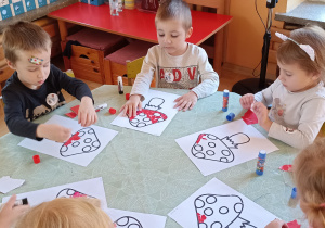 dzieci wyklejają papierem kolorowym muchomora