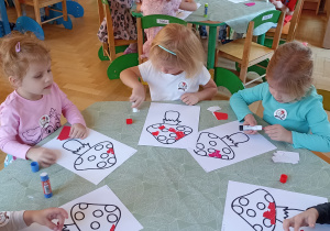 dzieci wyklejają papierem kolorowym muchomora