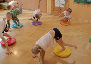 dzieci ćwiczą z kolorowymi krążkami