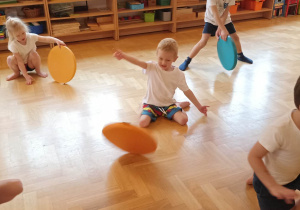dzieci ćwiczą z kolorowymi krążkami