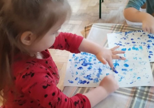 Dziewczynka "stempluje palcami" deszczyk