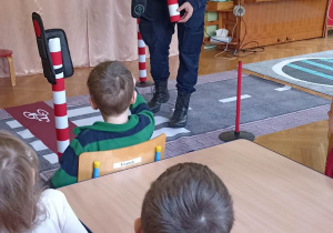 pan ze straży miejskiej pokazuje znak drogowy