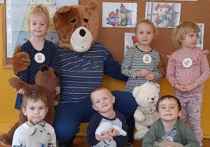 Dzieci siedzą na dywanie i pozują do zdęacia