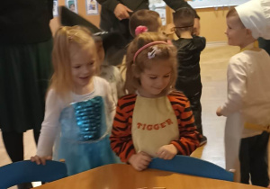 dzieci stoją przy stoliku