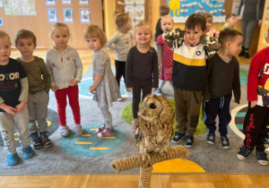 dzieci pozują do zdjęcia grupowego z sową