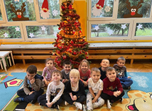 Dzieci pozują do zdjęcia przed choinką