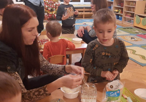 dzieci razem z rodzicami wykonują świeczniki