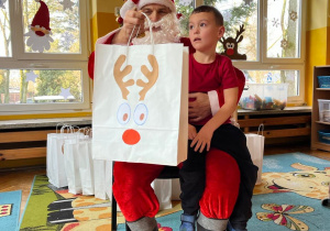 Dziecko pozuje do zdjęcia ze Św. Mikołajem