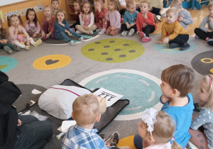 dzieci siedzą na dywanie