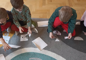 dzieci na dywanie układają puzzle