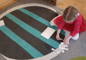 dzieci na dywanie układają puzzle