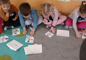 dzieci na dywanie układają puzzle