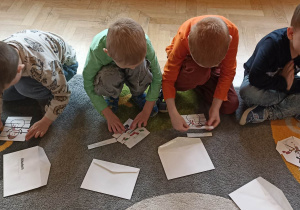 dzieci na dywanie układają puzzle