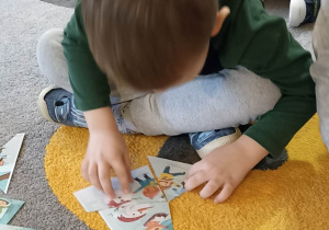 dzieci układają obrazek na dywanie