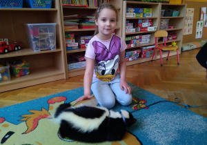 Dzieci głaszczą skunksa