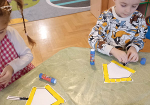 dzieci wyklejają karmnik dla ptaków