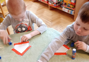 dzieci wyklejają karmnik dla ptaków