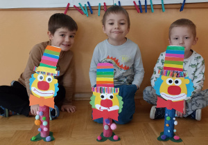 dzieci siedzą za klaunem z papieru