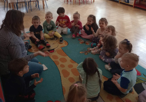 Dzieci z panią pedagog ilustrują ruchem piosenkę