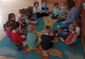 Dzieci z panią pedagog ilustrują ruchem piosenkę