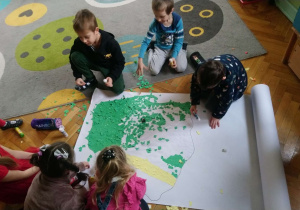 Dzieci wyklejają mapę