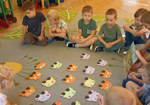 dzieci siedzą na dywanie
