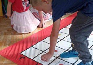 chłopiec stoi na macie do kodowania