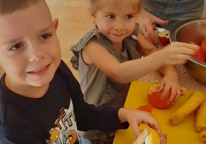 Dzieci obierają i kroją owoce