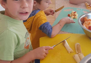 Dzieci obierają i kroją owoce