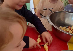 Dzieci obierają i kroją owoce