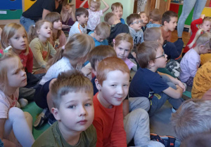 dzieci siedzą na dywanie