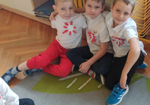 dzieci siedzą na dywanie